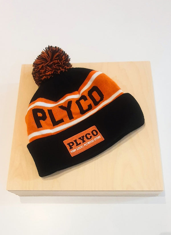 Plyco's famous orange, white and black beanie featuring a pom pom on a white background