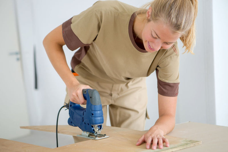 Australian female builder cuts through a sheet of Plyco's Radiata Pine Plywood sheets for a local plywood construction project 